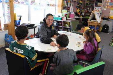 Teachers at a table with students.